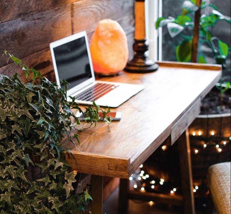 Arbetsrum med Saltlampa för bästa saltlampa effekt på vintage skrivbord av trä dator och mobil grön växt lampor på marken