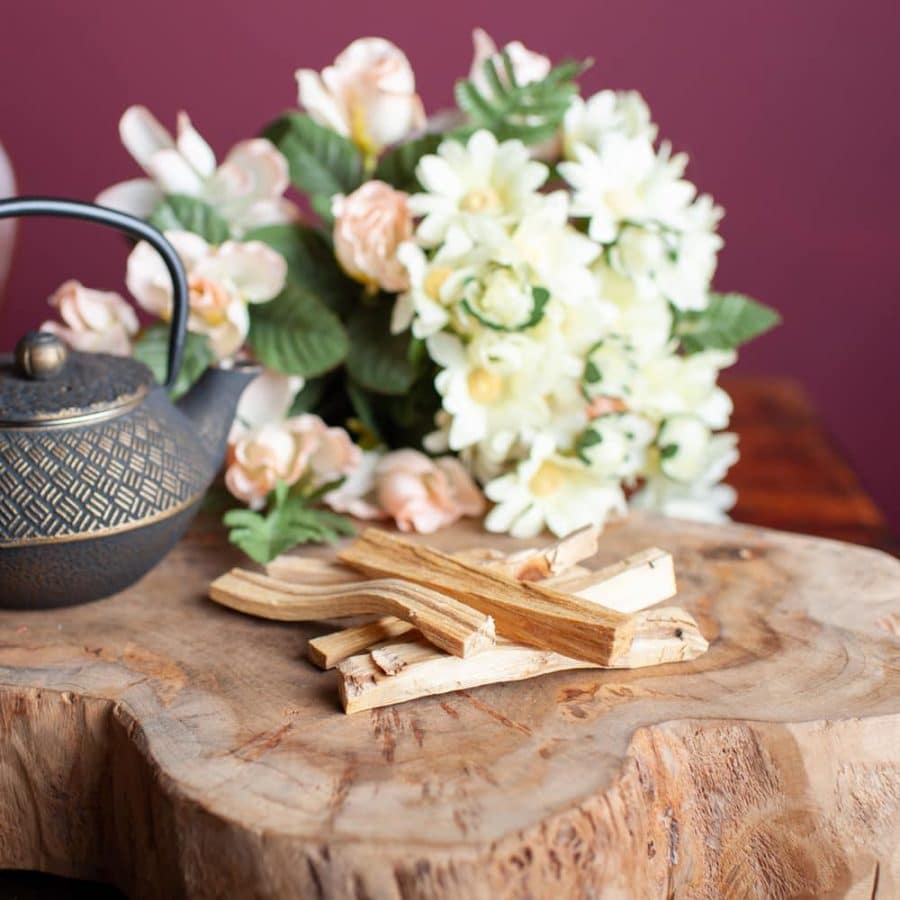 Palo Santo egenskaper blog Heligt trä bild på träbord blommor och tekanna